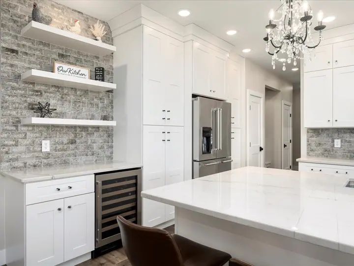 Remodeled kitchen with twin chandeliers over a stone island